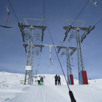 Schlepplifte Lüsch, hier mit dem ersten Teil einer Kurve, die sich mit schrägen Rollen über mehrere Stützen erstreckt. Die Stange in der Mitte dient dafür, dass im Fall einer Seilentgleisung das Förderseil nicht in Richtung des anderen Schlepplifts springt, Dezember 2011
