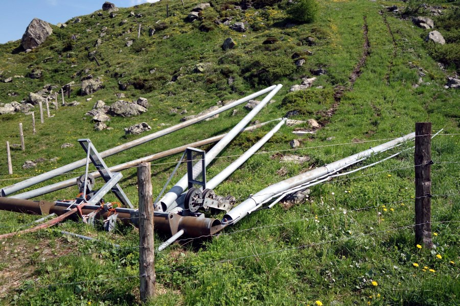 Stütze 2 des Schlepplifts Weisshorn 2 liegt noch nicht demontiert im Gras. Aufgrund der starken Beschädigung ist nicht davon auszugehen, dass diese Teile noch einmal irgendwo verwendet werden, Juli 2013