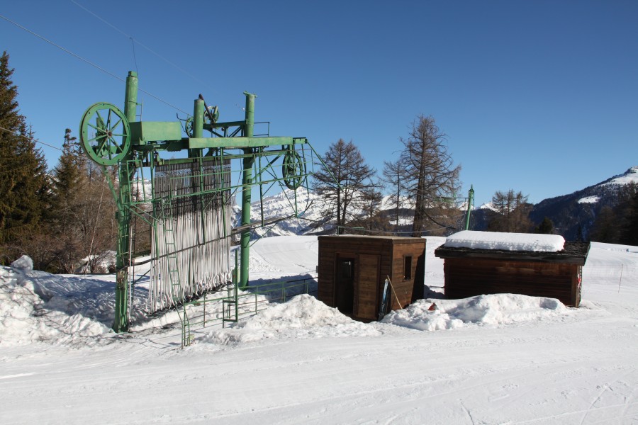 Talstation des Schlepplifts Tracuit. Da es hier unten keinen Strom gibt, wurde der Antrieb in die Bergstation gelegt, woraus die unübliche Anordnung mit fliegender Seilscheibe im Tal resultiert, März 2012